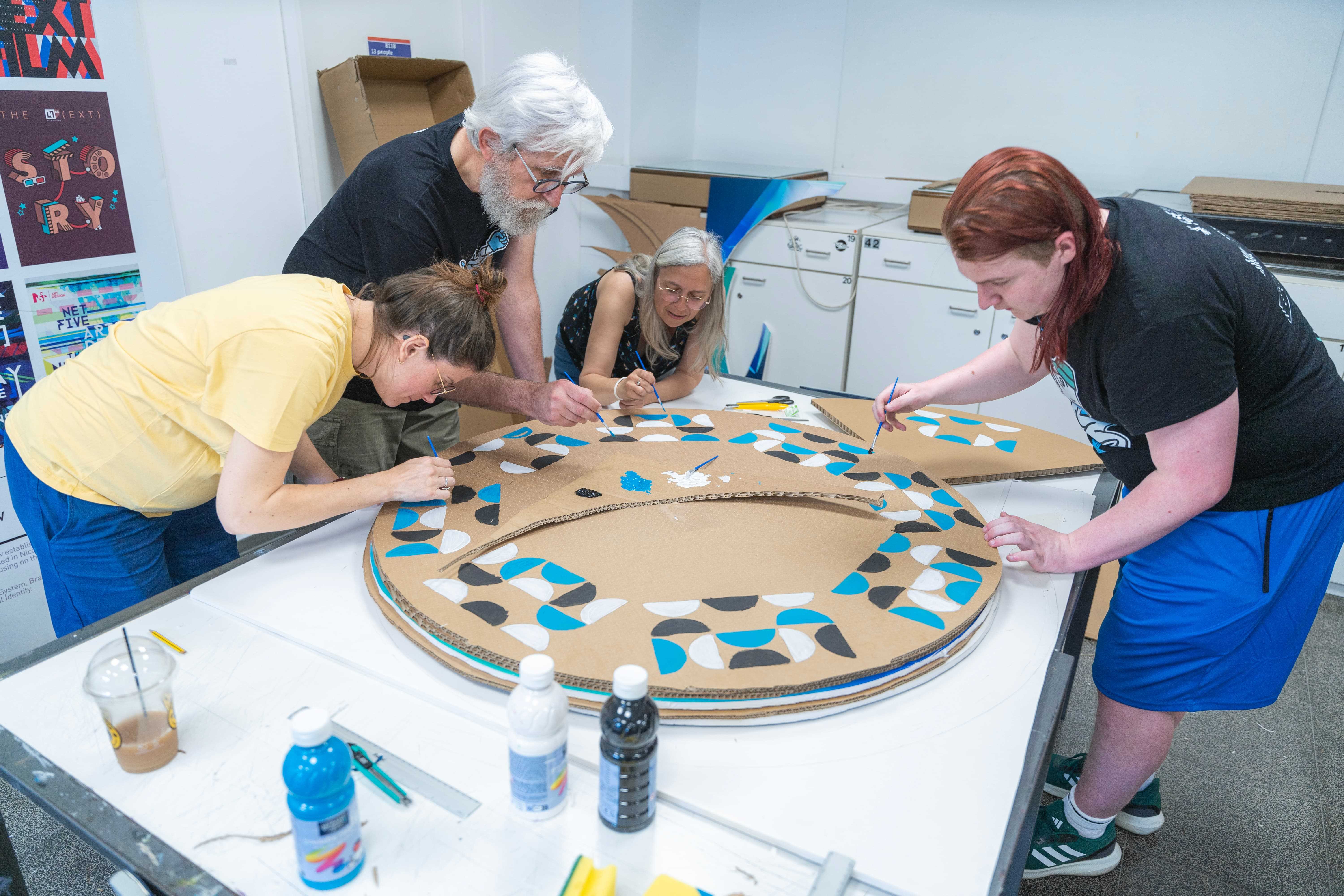 Group of staff and students painting during the sustainable workshop