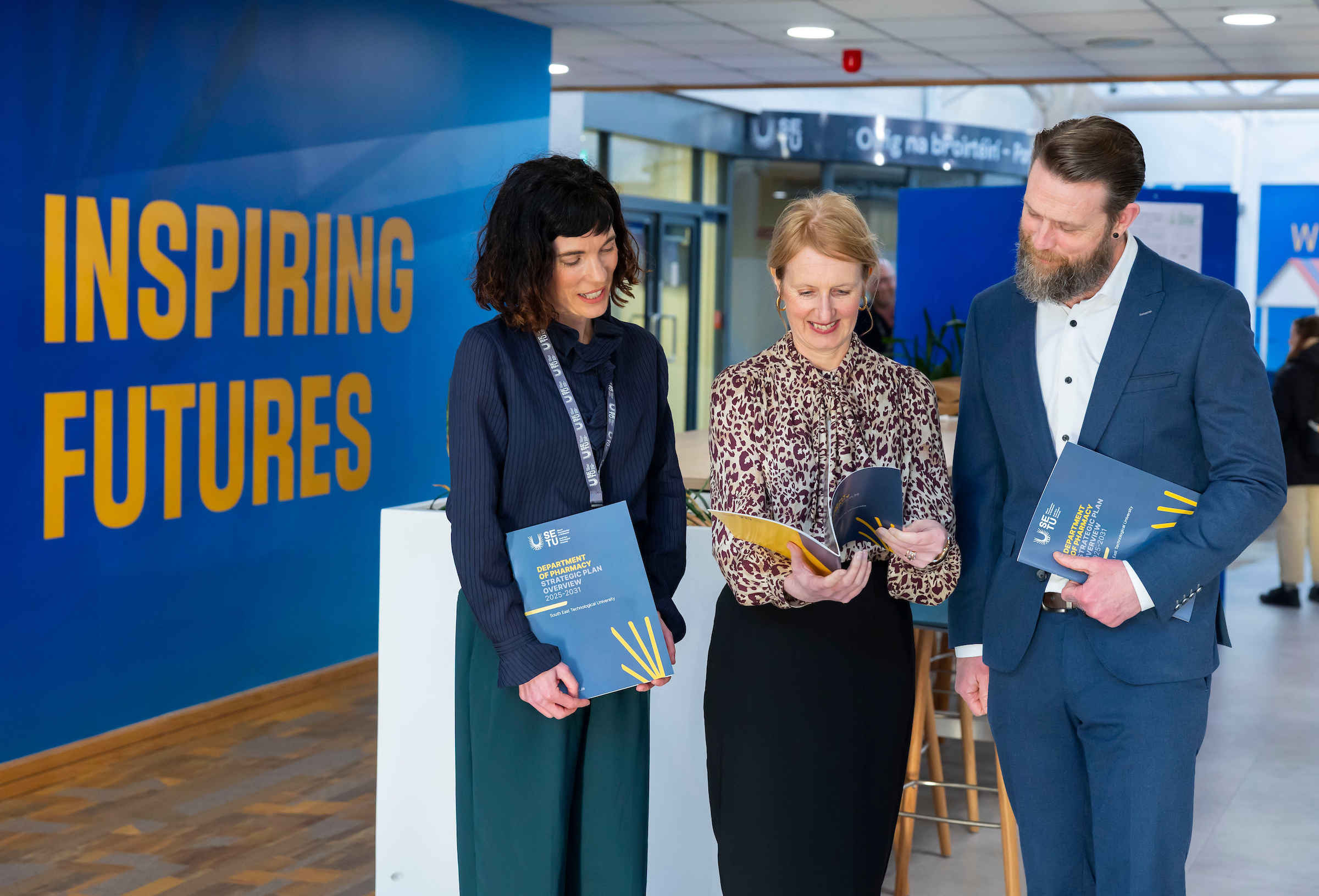 Claire Lennon, Veronica Campbell and Dr Laurence Fitzhenry reading departmental strategic plan