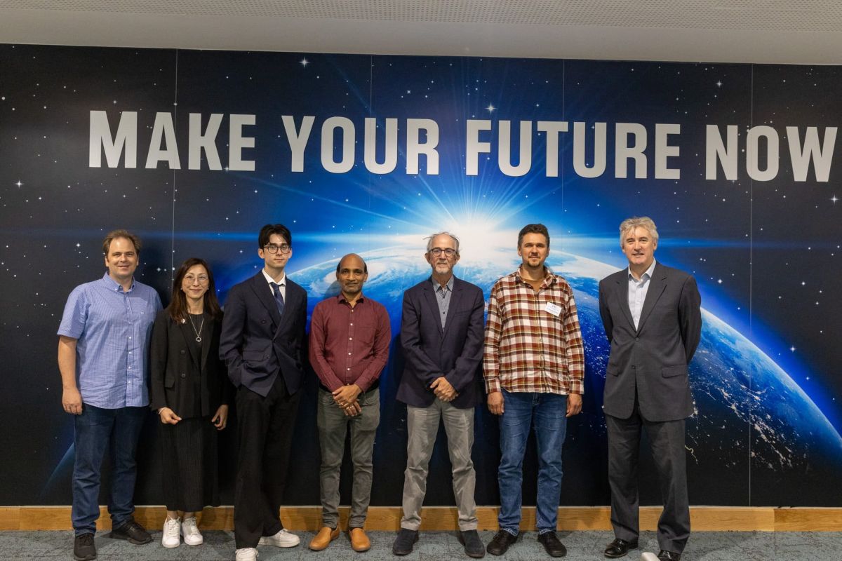 Key speakers standing in front of illuminated Earth backdrop with "Make Your Future Now" motivational text display