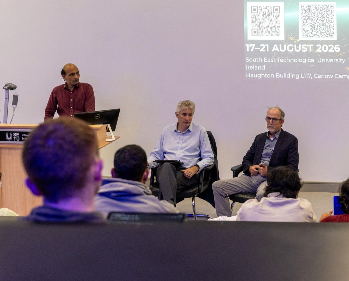 Panel discussion at SETU conference, August 2026, with three speakers seated and audience members in foreground.