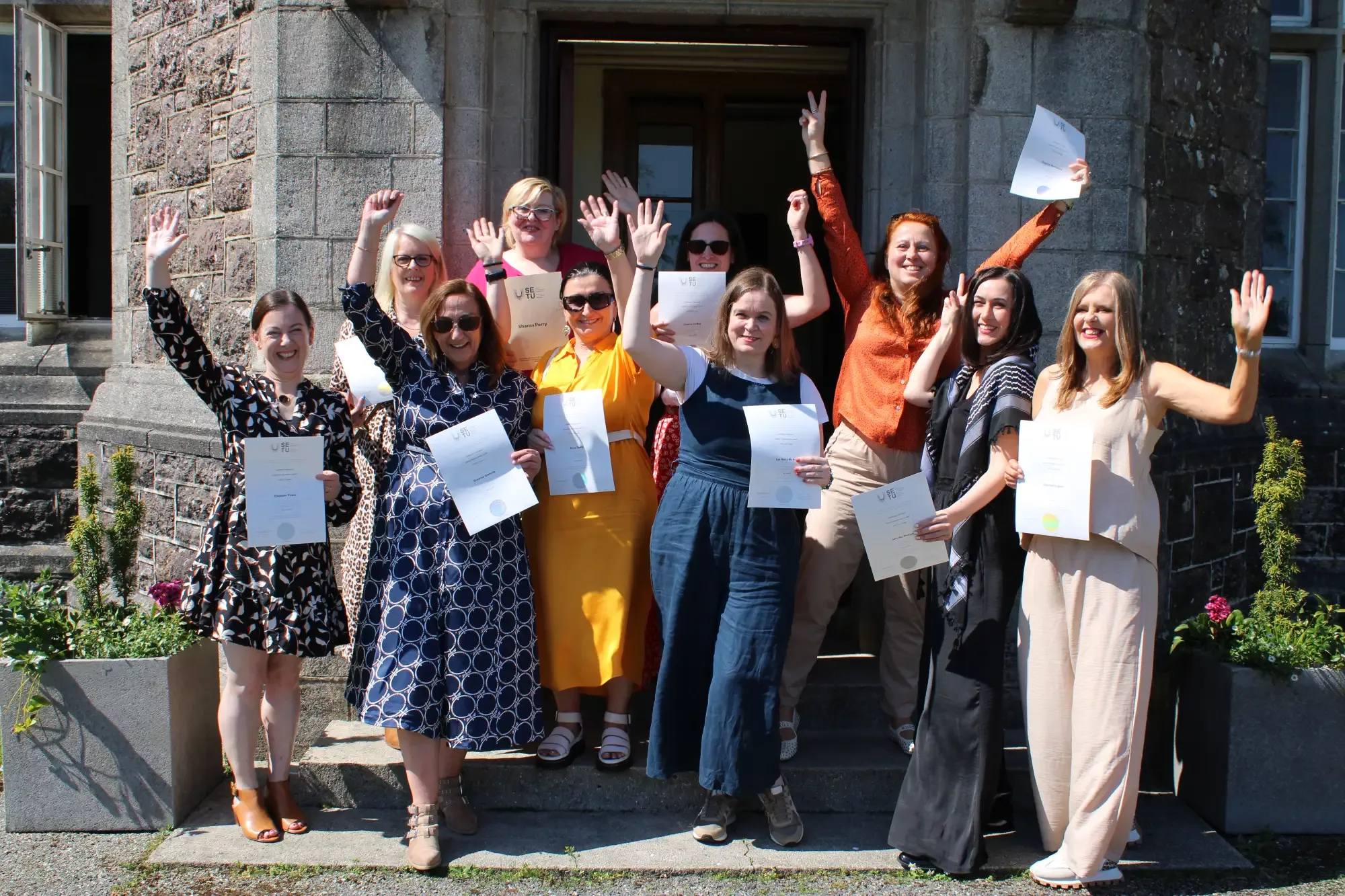WCI staff posing with their hands in the air and their certs.