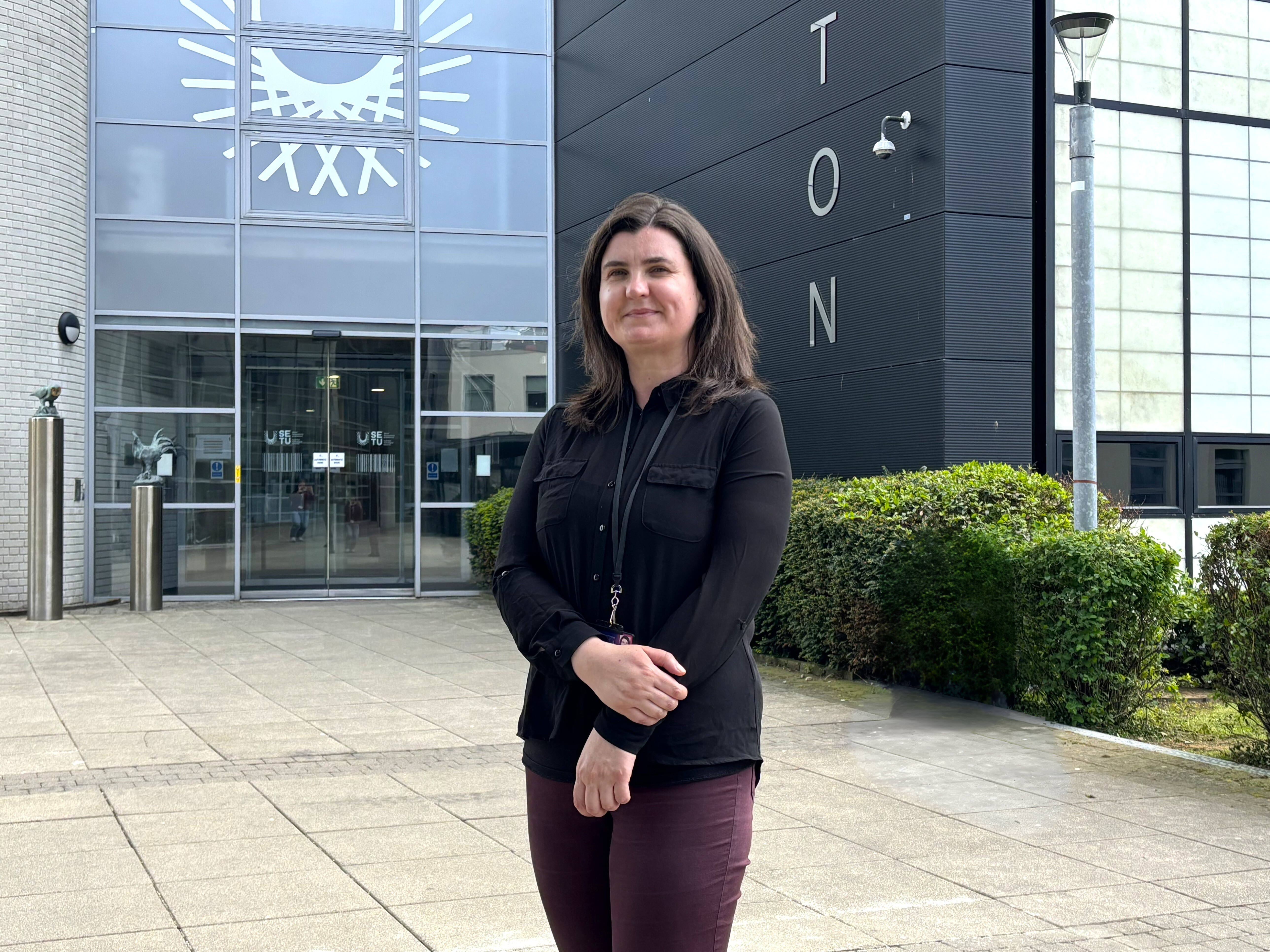 Muireann Prendergast standing in front of SETU's Walton IT building