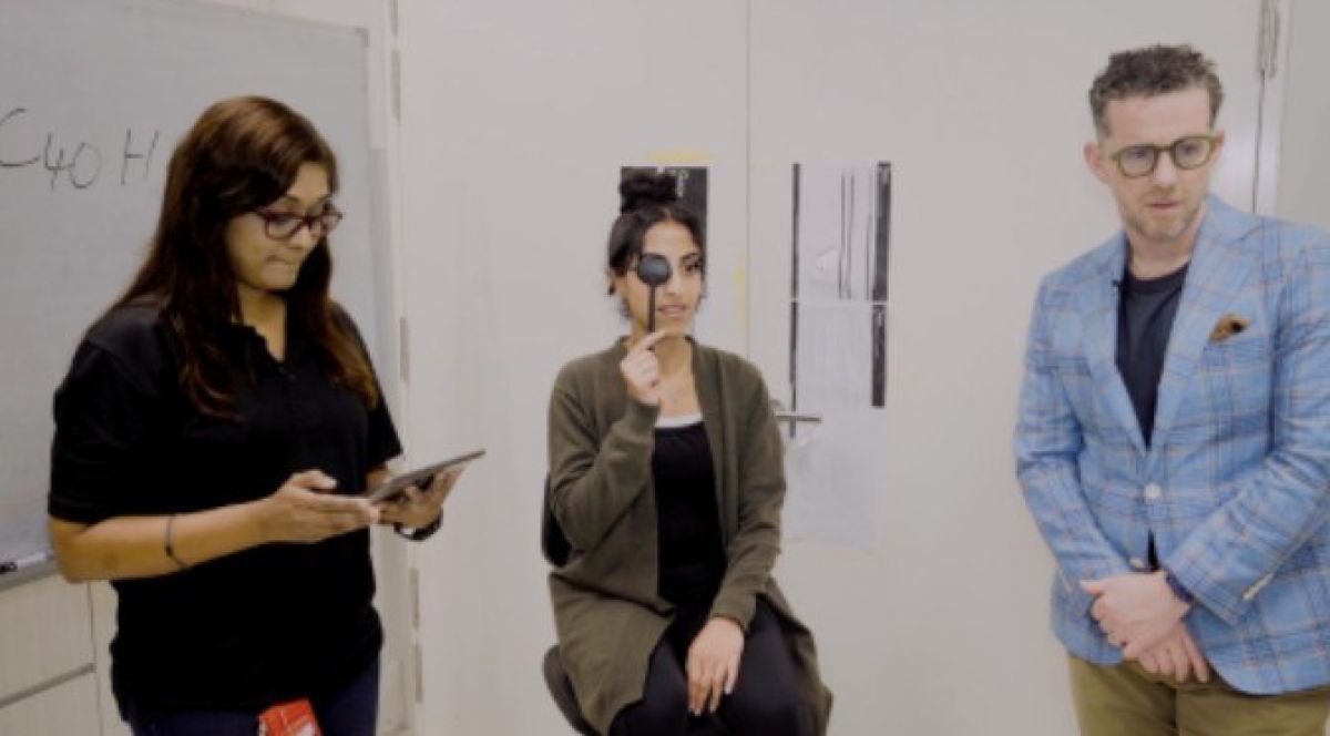 Woman having eye test surrounded by male and female researchers